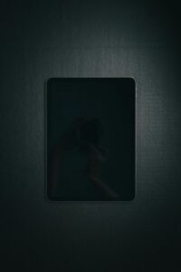 Minimalist photo of a sleek tablet with black surface, perfect for tech themes.