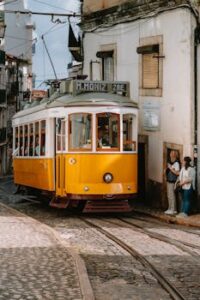 Vintage yellow tram navigating the cobblestone streets of Lisbon, Portugal.