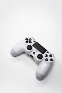 Minimalist image of a white gaming console controller isolated on a bright white background.
